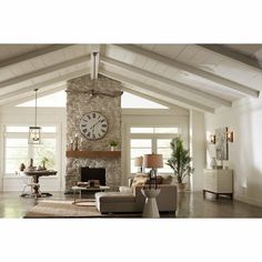 a living room filled with furniture and a large clock on the wall above it's fireplace