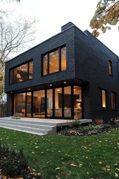 a modern black house with large windows and steps leading up to the upper floor area