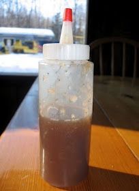 a plastic bottle filled with liquid sitting on top of a wooden table