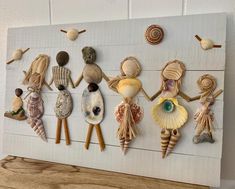 a group of sea shells hanging on a wall next to wooden pegs and seashells