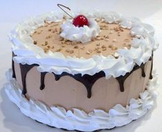 a chocolate cake with white frosting and a cherry on top