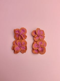 two orange and pink flower clips on a pink background