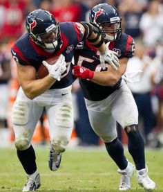 two football players are running with the ball in their hands and one is holding the other's hand