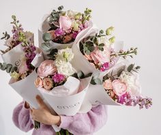 a woman holding a bunch of flowers in her hands with the words love written on it