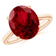 a ring with a large red stone on it's side, set in yellow gold