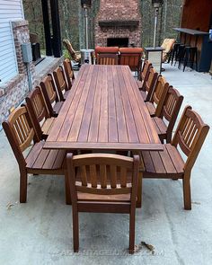 a large wooden table with chairs around it in front of a fire place and outdoor fireplace