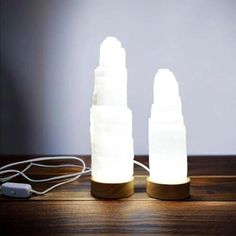 two white lights sitting on top of a wooden table