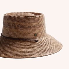 A woven bucket hat with a flat top, a slightly angled brim made of a darker brown straw and also features a brown drawstring. Casual Brown Paper Straw Hat, Brown Casual Paper Straw Hat, Casual Brown Woven Sun Hat, Casual Brown Woven Boater Hat, Casual Woven Brown Sun Hat, Casual Brown Braided Straw Hat, Brown Braided Fedora Sun Hat, Adjustable Brown Paper Straw Fedora, Brown Paper Straw Hat With Short Brim