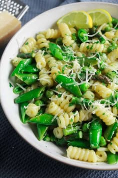 a white bowl filled with pasta and green beans