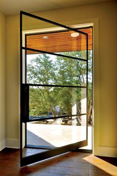 an open door leading to a parking lot with trees in the backgroung