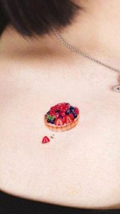 a close up of a woman's chest with a piece of fruit on it