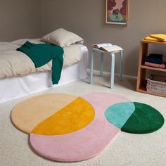 a bed room with a neatly made bed and three rugs on the floor next to each other