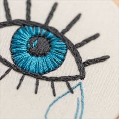 Hand embroidery hoop featuring an eye and a falling tear. Easy Stitches Embroidery, Eye Embroidery Simple, Third Eye Embroidery, Eye Embroidery Pattern, Evil Eye Embroidery Design, Eyeball Embroidery, Embroidery Patterns Beginner, Eye Embroidery Design, Evil Eye Embroidery