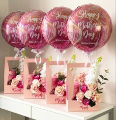 pink and gold mother's day balloons on a table with flowers in vases