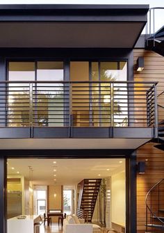 an open living room with stairs leading to the upper floor and second story balcony area