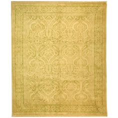 a yellow and green rug with an intricate design on the bottom, in front of a white background