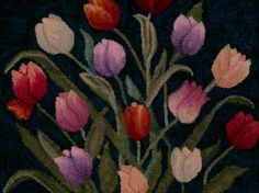 a bunch of tulips are in a vase on a black tablecloth with red, pink and white flowers