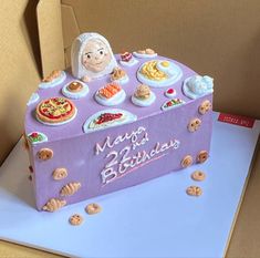 a birthday cake in the shape of a box with cookies and other foods on it