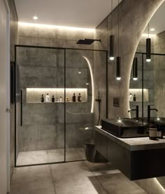 a modern bathroom with two sinks and large mirrors on the wall, along with lighted lights