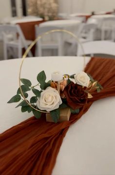 a close up of a flower arrangement on a table with white chairs in the background