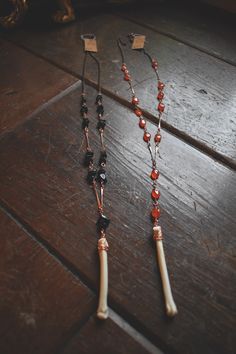 Black agate and carnelian Y necklaces w/ coyote paw bone. On vintage bar chain from the 60s, and new chain. Find pieces like these and more at www.deadthingsbysarah.com! Vintage Bar, The 60s