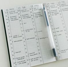 a notepad with a pen on top of it next to an open planner book