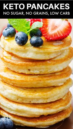 a stack of pancakes with blueberries and strawberries on top