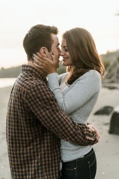 a man and woman kissing on the beach