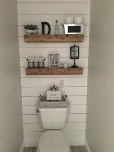 a white toilet sitting in a bathroom next to two floating shelves