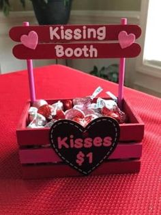 a valentine's day treat in a box on a table with a sign that says kissing booth