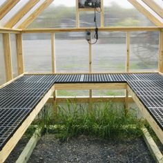 the inside of a greenhouse with two benches in front of it and grass growing on the ground