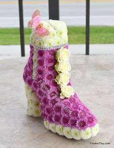 a pair of pink and white boots with flowers on the inside, sitting on a patio