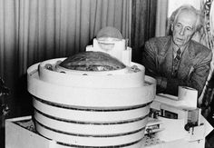 black and white photograph of man looking at an object in the shape of a spaceship