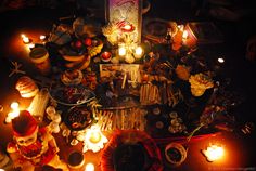 a table with candles and other items on it in the middle of a dark room