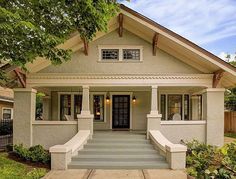 a small house with steps leading up to the front door and entry way that is painted white