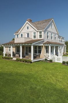 a large white house sitting on top of a lush green field