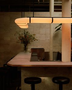 the lights are hanging over the counter in the restaurant's dining room, which also features stools