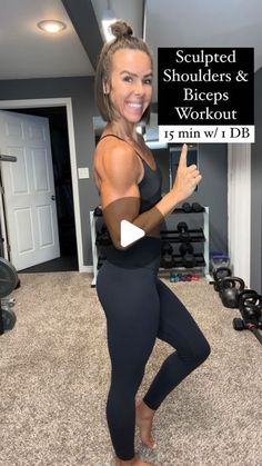 a woman standing in a room holding up a sign that says sculpted shoulders and biceps workout