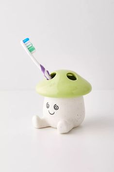 a toothbrush holder with a green mushroom on it