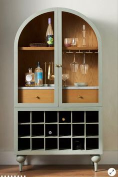 a cabinet with wine glasses and bottles in it