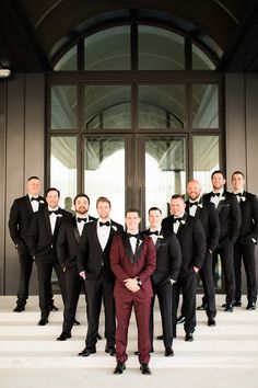 a group of men in tuxedos posing for a photo on the steps outside a building