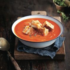 a bowl of tomato soup with croutons on top