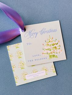 two christmas cards with ribbons on top of them next to a purple bow and ribbon