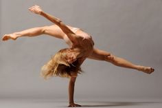 a woman is doing a handstand on one leg with her legs spread out