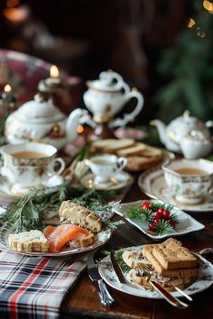 a table topped with plates and cups filled with food next to teapots on top of a wooden table