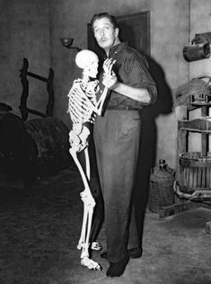 a man standing next to a skeleton in a room