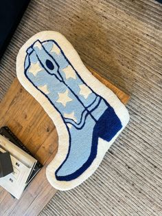 a blue and white rug on the floor next to a wooden table with a cell phone