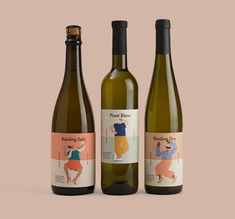 three wine bottles with labels on them sitting side by side in front of a beige background