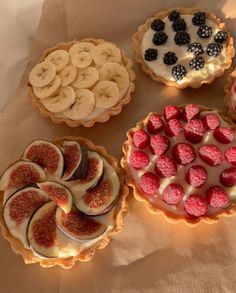 four pies with different toppings are arranged on a table