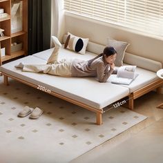 a woman laying on top of a bed next to a book shelf filled with books